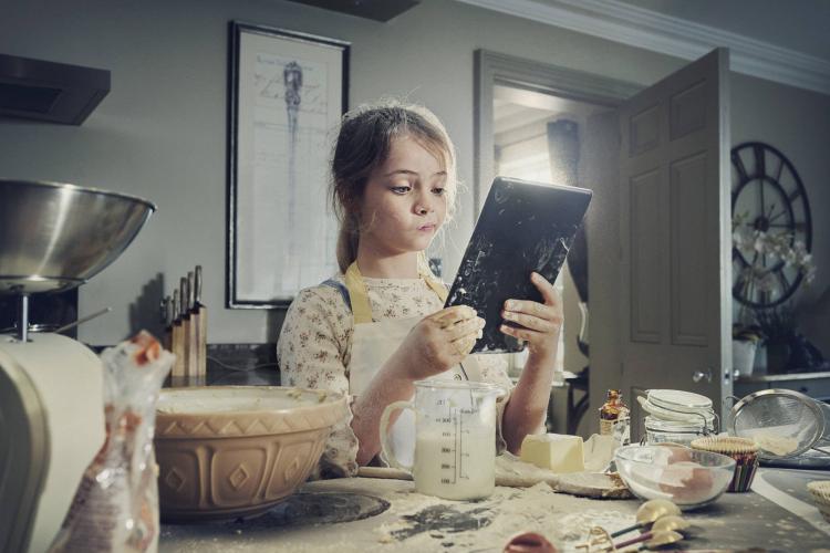 Niña horneando con una tableta